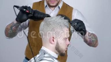 沙龙里的男式发型。 理发店里的人发干。 理发师用吹风机做发型。 做完美容。 吹风机